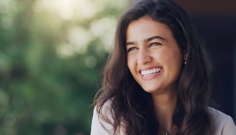 Happy young brunette girl smiling and looking off into the distance